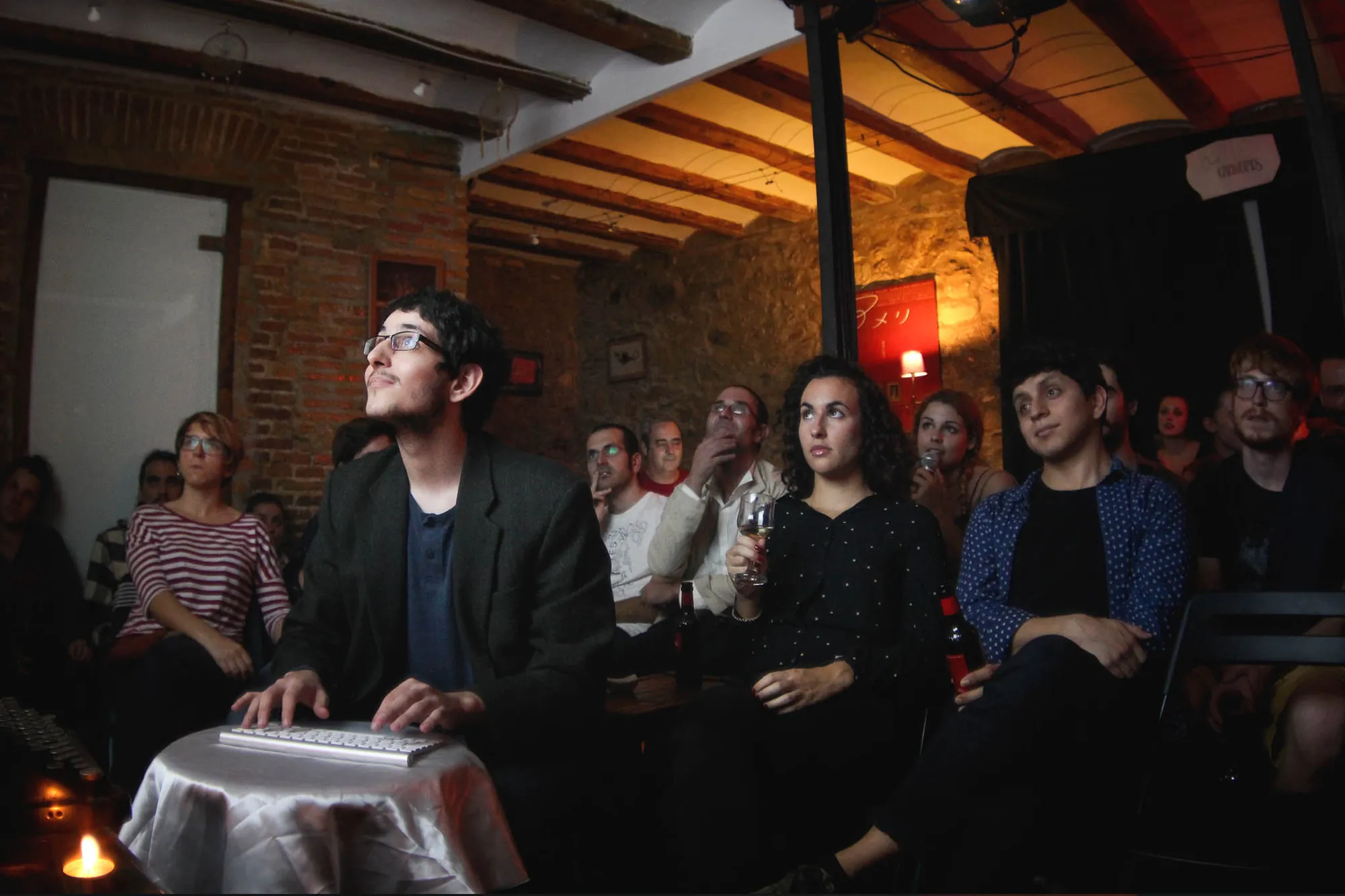 A writer at a keyboard among the audience at Club Cronopios, Barcelona, 2015